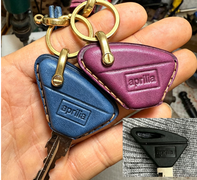 Close-up of embossed Aprilia logo on vegetable-tanned leather key case for RS457