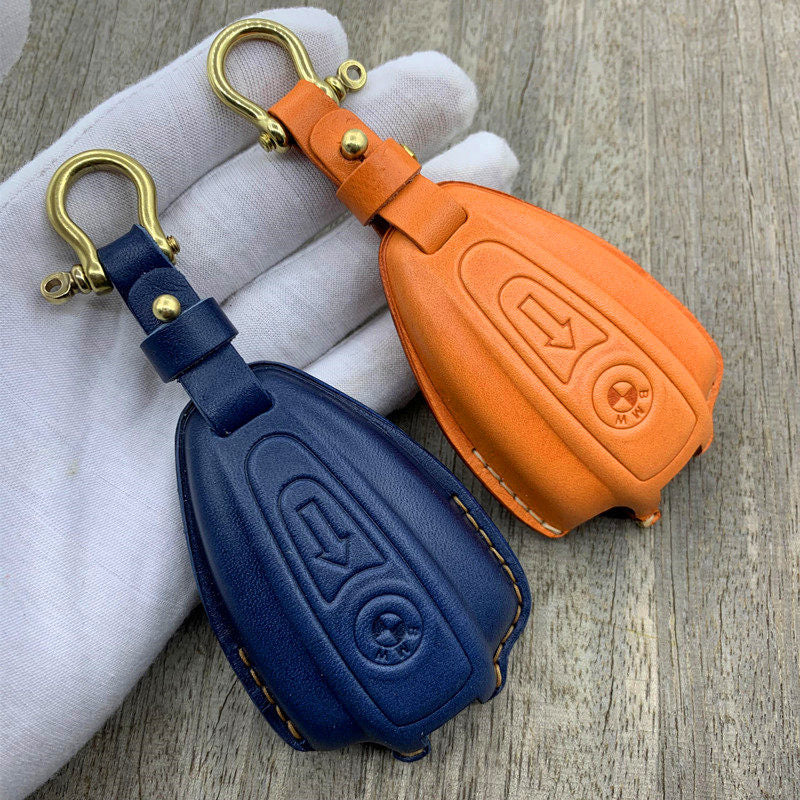 Custom-molded handmade leather key case for BMW R18 in orange and navy with brass S-hook